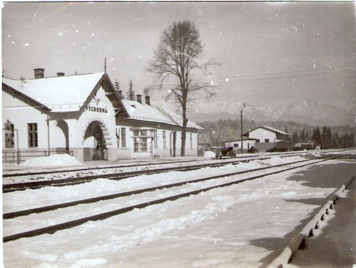  Východná - výpravná budova a sklad. Šikmý pohľad zo strany koľají od Žiliny. Vzadu drezína a nákladné vozne. Foto: Anon., cca 1950. 119 x 90 