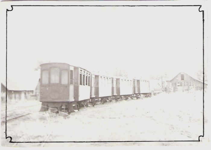  Súprava 4 tramvajových dvojnápravových prívesov v stanici Vígľaš. Nárožný pohľad. Vpravo vzadu depo s ručným portál. žeriavom. Vľavo ďalšia budova. Foto: V. Hlávek, 1976. 80 x 53 