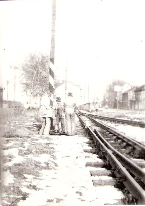  Trenčianska Teplá - koľajisko el. stanice. Pohľad od prvej výhybky depa k výpr. budove. Vzadu výpr. budova, vpravo obyt. budovy, vľavo mrežové osvetľovacie stožiare. Pri výhybke tri deti. Foto: V. Hlávek, 1978. 63 x 87 