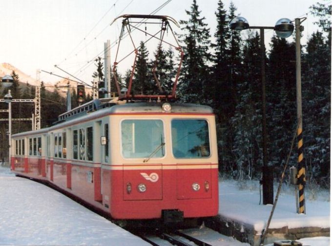  Elektrická motorová ozubnicová jednotka EMU 29.0 pri nástupišti v stanici Štrbské Pleso. Pohľad predobočný. Osvetľovacie stĺpy. Foto: Anon., cca 2000. 129 x 88, COLOR 