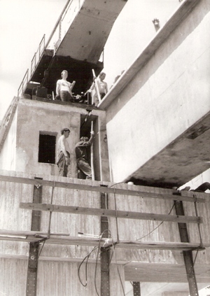  Pohľad zdola robotníkov na betónovom pilieri Prístav. mosta v Bratislave, na ktorý mostný žeriav krokodíl ukladá betón. prefabr. nosník, Foto: Macura M., cca 1980. (evid. aj v tab. Foto fond nový -Technika), 180 x 130 mm 