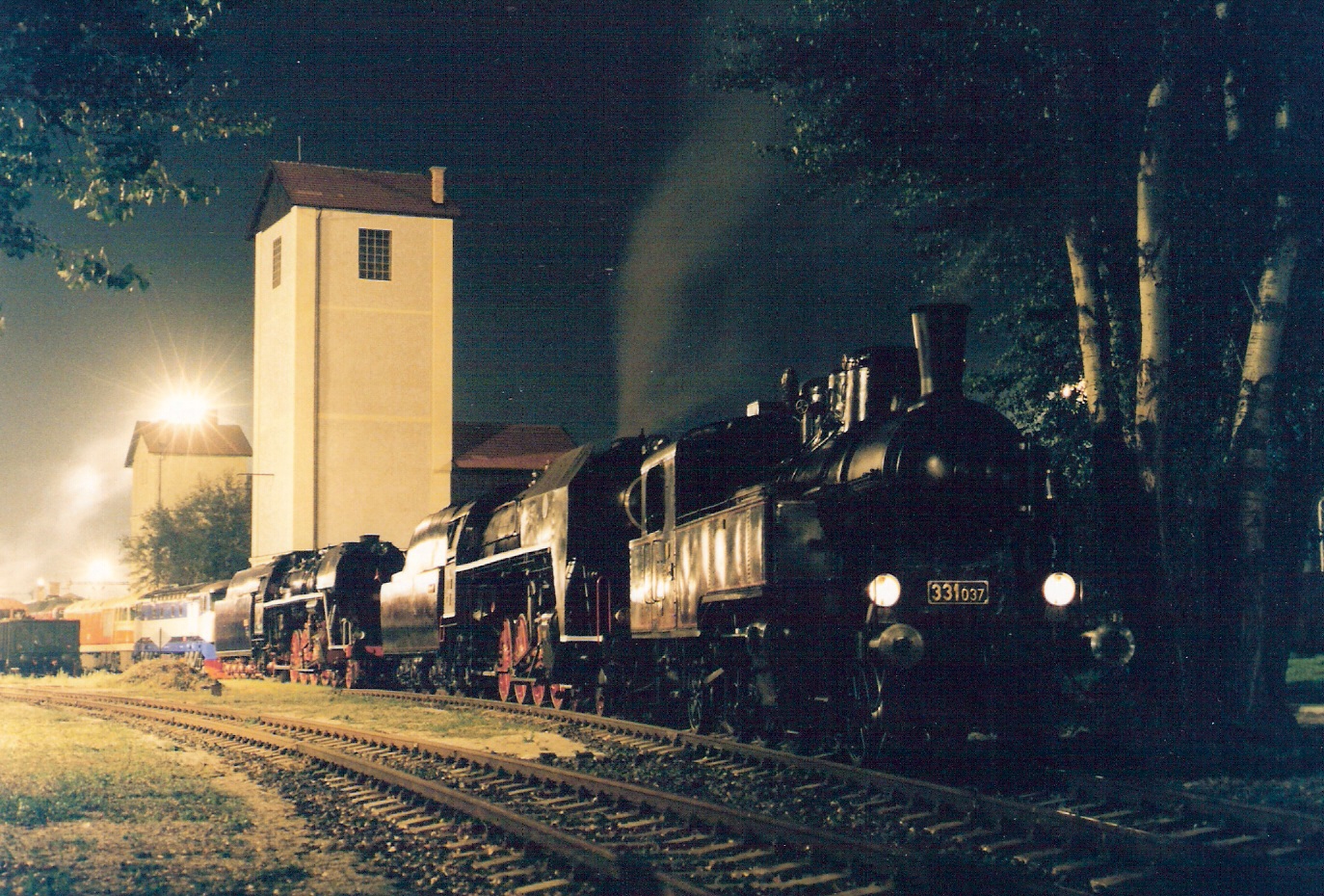  Par. rušne 331.037, 475.196, 498.104, T 478.1002 a T 678.012 za sebou v starom depe Bratislava vých. počas Zrazu 1999. Nočný pohľ. zprava zpredu. Vľ. vodárne, vpravo topoľ. Foto: M. Entner, 9.1999. 180 x 126 mm, COLOR 