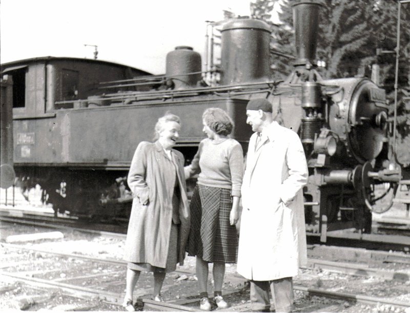  Parný rušeň 410.004 v Tatranskej Lomnici. Pohľad zprava zpredu. V popredí stoja dve ženy a jeden muž v civile. Foto: Anon., 1949, archív Koutný. 179 x 130 mm 