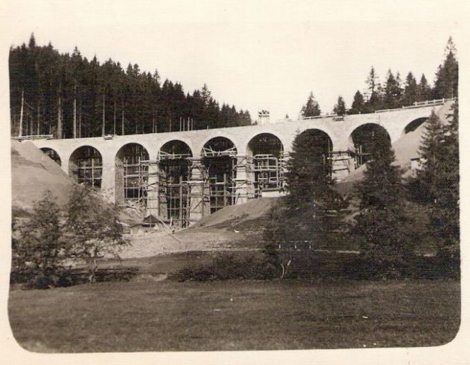  Rozostavaný viadukt medzi Telgártom a Vernárom. Hotové murárske dielo, drevené lešenie. Pohľad zboku zdola. Vzadu les. Foto: Anon., cca 1933. 104 x 70 