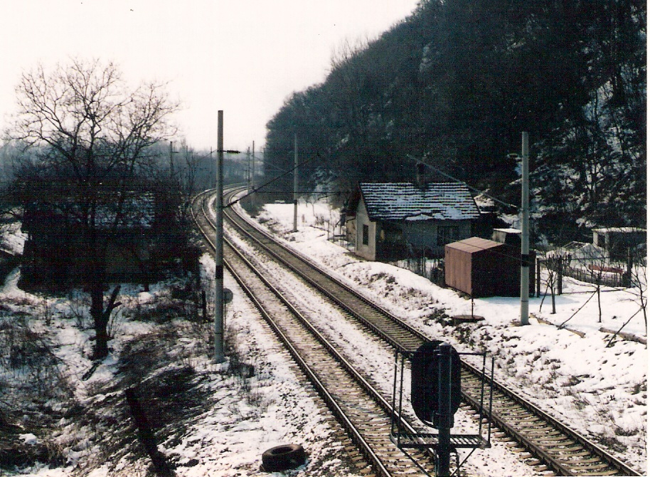  Nové Mesto nad Váhom - Melčice, km 103,95 - strážny a obytný dom, elektrifikovaná dvojkoľajná trať. Pohľad v osi koľaje od Žiliny z nadhľadu. Foto: M. Entner, 26.2.1995. 126 x 89, COLOR 