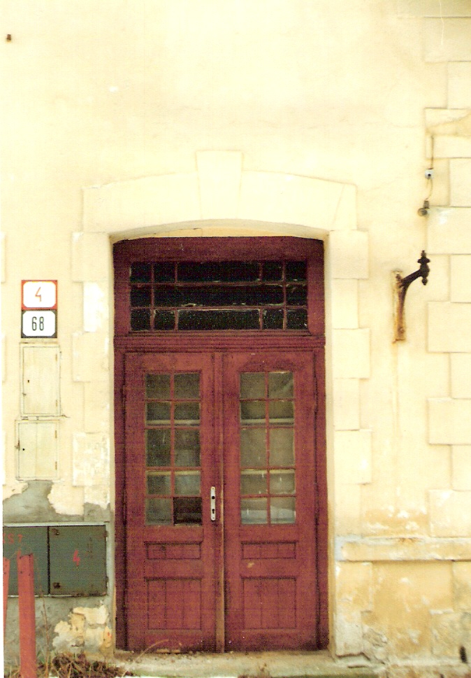  Rudno nad Hronom - výpravná budova stará. Čelný pohľad na vstupné dvere od koľají. Konzola na petrolejovú lampu. Foto: Anon., 1996. 89 x 126, COLOR 
