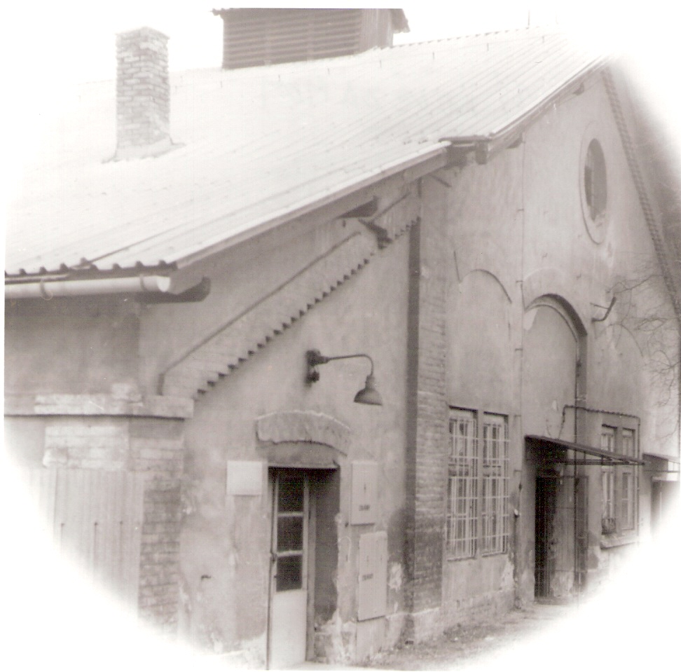  Nové Zámky - dielenská budova v obvode opravovne vozňov (zrejme staré depo). Šikmý pohľad na fasádu s bývalými bránami. Foto: J. Kubáček, cca 1995. 120 x 120 