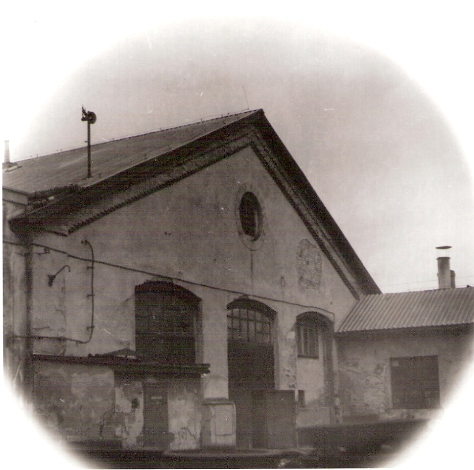  Nové Zámky - dielenská budova v obvode opravovne vozňov (zrejme staré depo). Šikmý pohľad na fasádu s bývalými bránami. Foto: J. Kubáček, cca 1995. 120 x 120 