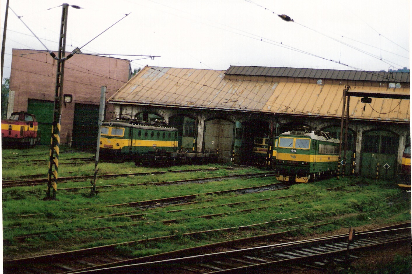  Žilina - depo, elektrická časť. Šikmý pohľad na fasádu s bránami zo strany staničných koľají od Bratislavy. Foto: M. Entner, 11.8.1994. 178 x 125, COLOR 