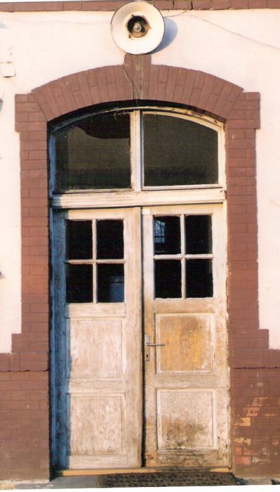  Nové Zámky - depo. Obytná budova. Čelný pohľad na vstupné dvere zo strany koľají. Foto: M. Entner, 26.2.1996. 89 x 126, COLOR 