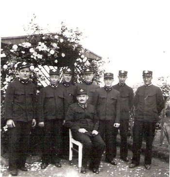  Skupina železničiarov v uniformách (jeden z nich sedí) pred záhradnou besiedkou, Rudoltice 1933, 54 x 54 mm, autor pravdepodobne Karel Šponar. 