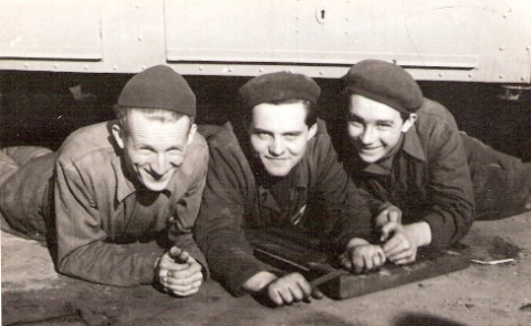  Traja učni pod autobusom. Text: Mladí brigádnici - budúci mechanici ČSAD - dielne. Foto: Salkay, 1950. 138 x 89 