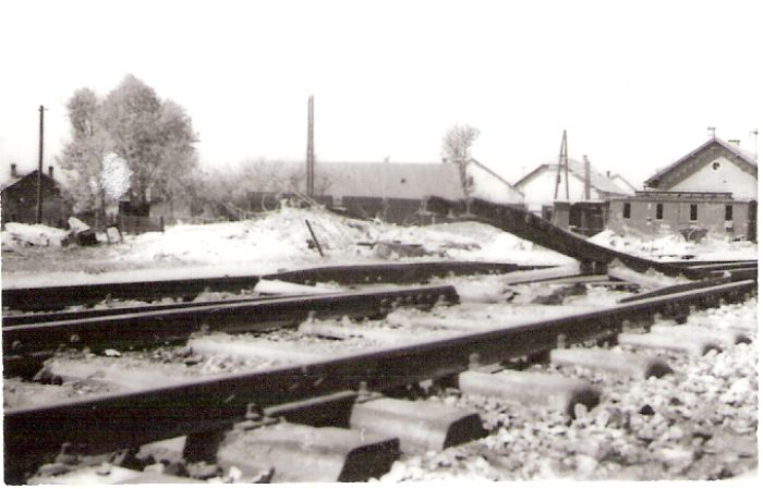  Vrútky os. st. - košické zhl. Pohľ. od Košíc smerom na obyt. dom pri košic. zhl. Vpredu výh. so znič. srdcovkou, pred domom skriňa vozňa s nápisom ČSD. Vz. obyt. domy. Foto: Anon., 1945, zbierka Klabník. 85 x 55 