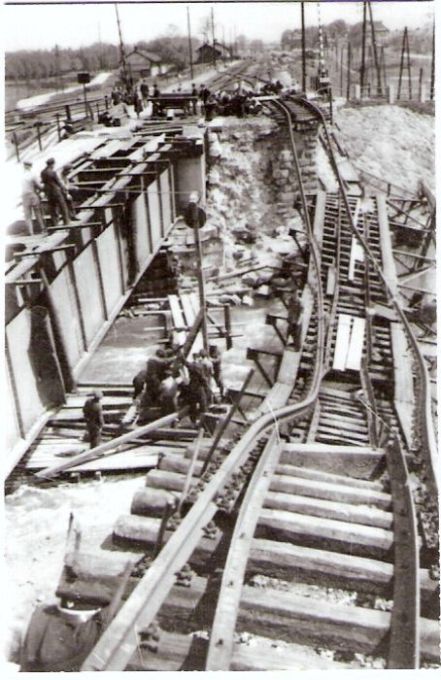  Vrútky os. st. - žilinské zhl. Pohľad od Žiliny v osi koľaje. Vľavo plech. most v oprave, vpravo strhnutý most. Za mostom priecestie s dvojdrôt. závorami. Vzadu stanica. Foto: Anon., 1945, zbierka Klabník. 57 x 87 