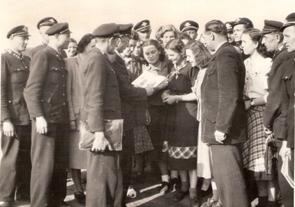  Skupina mužov a žien v civile i rovnošatách. Text: Budúce sprievodkyne a telegrafistky v rozhovore s prednostom žel. stanice v N. Zámkoch. Foto: Anon., 8.6.1952 (?). 174 x 129 