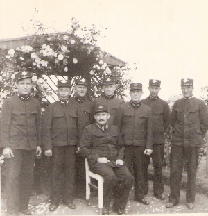  Skupina mužov v železničných rovnošatách pred záhradným altánkom. Text: Rudoltice, 1933. Foto: zrejme Karel Šponar. 80 x 80 