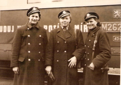  Tri polovičné postavy žien v železničných rovnošatách s taškami sprievodcov pred motorovým vozňom M 262.0. Anonym, cca 1955. 155 x 115 