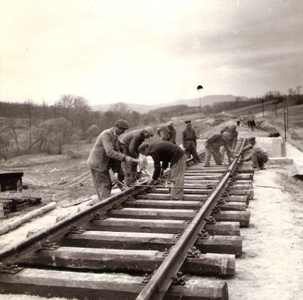  Skupina robotníkov s rozchodkou pri montáži koľaj. zvršku na drev. podvaloch. Text: Stavba Trate 1. mája Selce - Nograd Szakal. Foto: Kľučka, cca 1955 127 x 125 