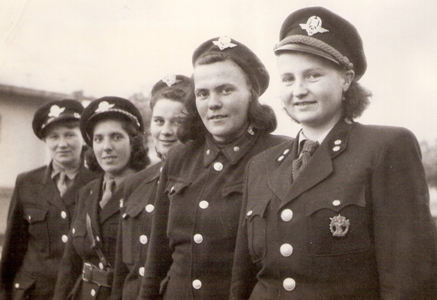  Skupina žien v rovnošatách železnice a železničnej ochrannej stráže (polovičné postavy). Text: Škola pre ochrannú stráž v Pezinku. Anonym, cca 1950. 170 x 120 