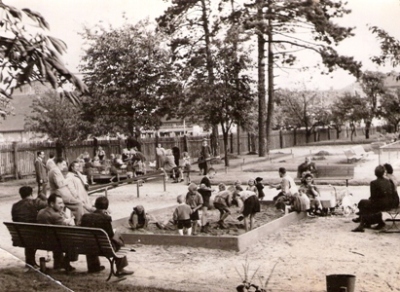  Detské ihrisko s hrajúcimi sa deťmi a dozerajúcimi dospelými. Text: Detské ihrisko na Žabotovej ul. v Bratislave. Foto: Kľučka, cca 1950. 170 x 125 