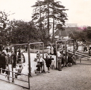  Detské ihrisko s hrajúcimi sa deťmi a dozerajúcimi dospelými. Text: Detské ihrisko na Žabotovej ul. v Bratislave, Foto: Kľučka, cca 1950. 130 x 125 